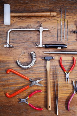 Kuyumcular takı işyerinde araçları üst görünümü. Profesyonel araçlar la zanaat takı yapmak için Masaüstü. Rustik ahşap arka plan üzerinde araç seti