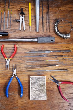 Kuyumcular takı işyerinde araçları üst görünümü. Profesyonel araçlar la zanaat takı yapmak için Masaüstü. Rustik ahşap arka plan üzerinde araç seti