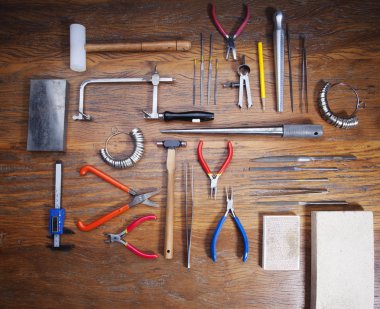 Kuyumcular takı işyerinde araçları üst görünümü. Profesyonel araçlar la zanaat takı yapmak için Masaüstü. Rustik ahşap arka plan üzerinde araç seti