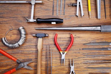 Kuyumcular takı işyerinde araçları üst görünümü. Profesyonel araçlar la zanaat takı yapmak için Masaüstü. Rustik ahşap arka plan üzerinde araç seti