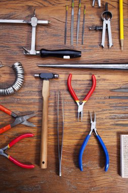 Kuyumcular takı işyerinde araçları üst görünümü. Profesyonel araçlar la zanaat takı yapmak için Masaüstü. Rustik ahşap arka plan üzerinde araç seti