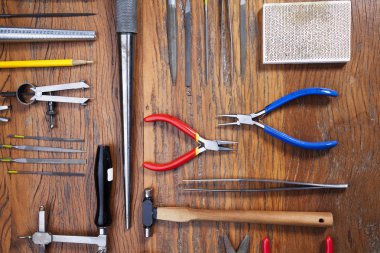 Kuyumcular takı işyerinde araçları üst görünümü. Profesyonel araçlar la zanaat takı yapmak için Masaüstü. Rustik ahşap arka plan üzerinde araç seti