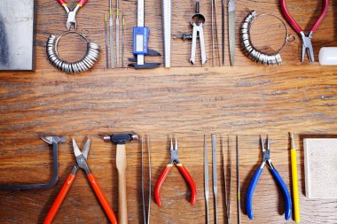 Kuyumcular takı işyerinde araçları üst görünümü. Profesyonel araçlar la zanaat takı yapmak için Masaüstü. Rustik ahşap arka plan üzerinde araç seti