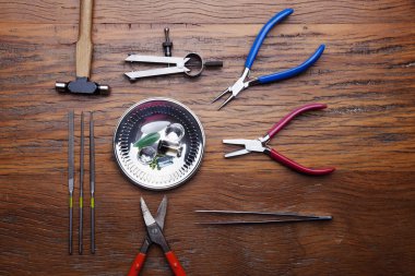 Kuyumcular takı işyerinde araçları üst görünümü. Profesyonel araçlar la zanaat takı yapmak için Masaüstü. rustik ahşap arka plan üzerinde araçlar