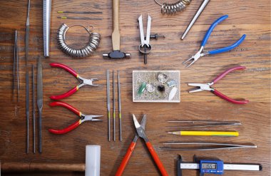 Kuyumcular takı işyerinde araçları üst görünümü. Profesyonel araçlar la zanaat takı yapmak için Masaüstü. rustik ahşap arka plan üzerinde araçlar