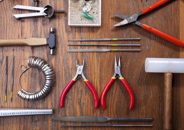 Kuyumcular takı işyerinde araçları üst görünümü. Profesyonel araçlar la zanaat takı yapmak için Masaüstü. rustik ahşap arka plan üzerinde araçlar