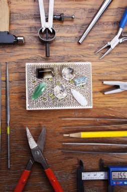 Kuyumcular takı işyerinde araçları üst görünümü. Profesyonel araçlar la zanaat takı yapmak için Masaüstü. rustik ahşap arka plan üzerinde araçlar