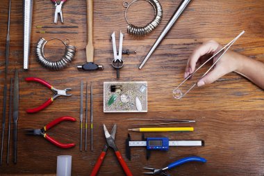 Kuyumcular takı işyerinde araçları üst görünümü. Profesyonel araçlar la zanaat takı yapmak için Masaüstü. rustik ahşap arka plan üzerinde araçlar