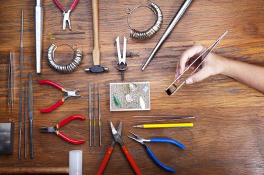 Kuyumcular takı işyerinde araçları üst görünümü. Profesyonel araçlar la zanaat takı yapmak için Masaüstü. rustik ahşap arka plan üzerinde araçlar
