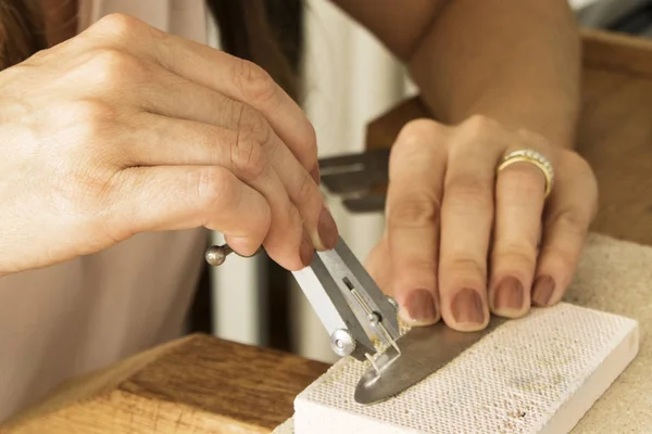 Different goldsmiths tools on the jewelry workplace. Jeweler at work in jewelry. Desktop for craft jewelry making with professional tools. Close up view of tools