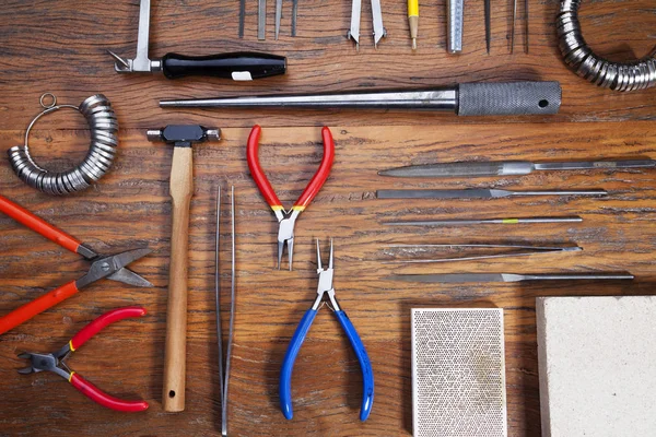 Kuyumcular takı işyerinde araçları üst görünümü. Profesyonel araçlar la zanaat takı yapmak için Masaüstü. Rustik ahşap arka plan üzerinde araç seti