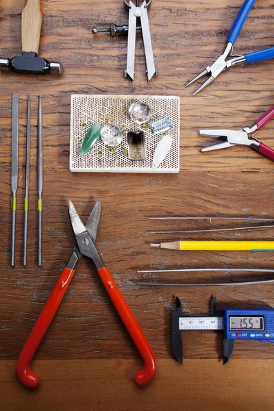 Kuyumcular takı işyerinde araçları üst görünümü. Profesyonel araçlar la zanaat takı yapmak için Masaüstü. rustik ahşap arka plan üzerinde araçlar