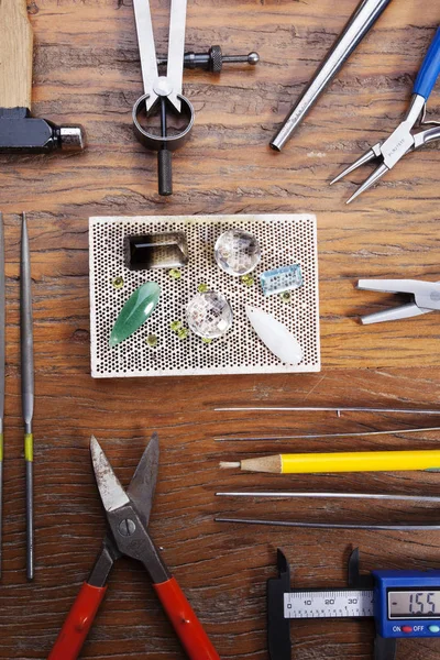 Kuyumcular takı işyerinde araçları üst görünümü. Profesyonel araçlar la zanaat takı yapmak için Masaüstü. rustik ahşap arka plan üzerinde araçlar