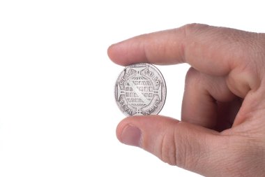 Beyaz arka planda izole edilmiş gümüş sikke, mali konsept erkek eli yakın  