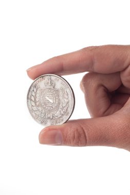 Beyaz arka planda izole edilmiş gümüş sikke, mali konsept erkek eli yakın  