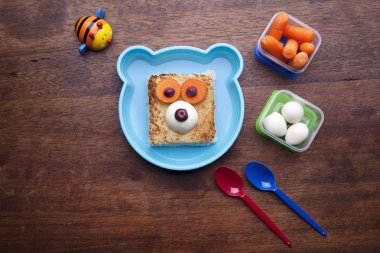 Ahşap arka planda komik yüz ile Yaratıcı sandviç