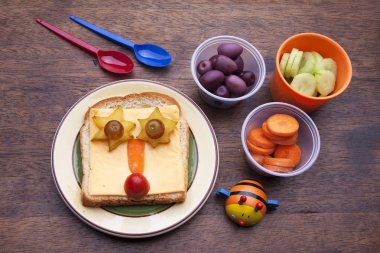 Ahşap arka planda komik yüz ile Yaratıcı sandviç