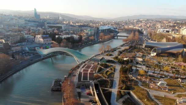 4k air view modern infrastructure soft morning light skyline bridge over the river. Тбилиси, Грузия. Парк Рике — стоковое видео