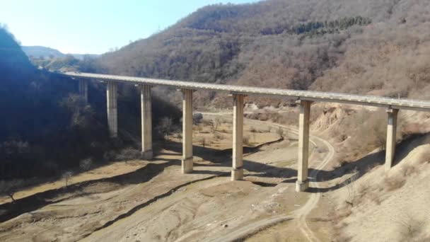 4k Luftbild verlorene Brücke im Gebirge mit Transportbewegung — Stockvideo