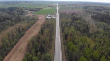güneş ışığında hareketli trafik ile orman şeridinin ortasında yolun 4k havadan görünümü