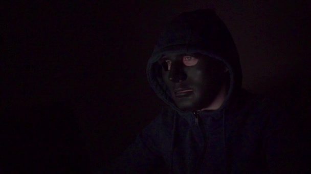 在计算机上工作的戴眼镜的软件开发人员黑客的肖像，投射代码数和字符反映在他的脸上。黑暗的房间充满了科技在镜头中放大 — 图库视频影像