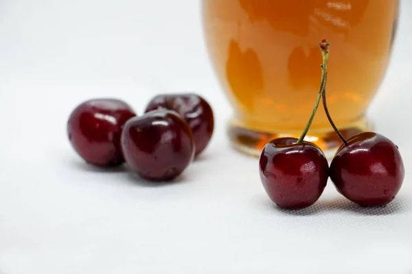 Manojos de cerezas dulces y una botella de jugo —  Fotos de Stock