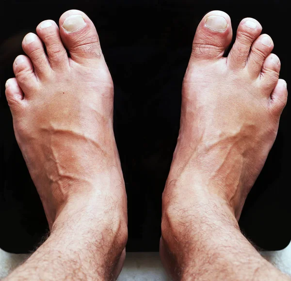 Men's feet on scales — Stock Photo, Image