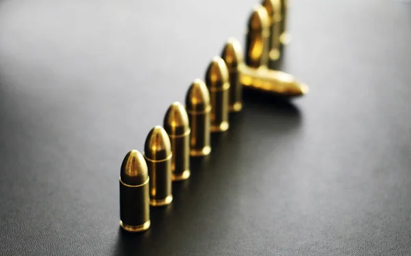 Pistolenkugeln reihen sich auf grauem Hintergrund — Stockfoto