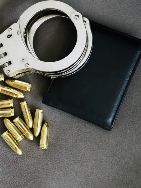 Handboeien, pistool kogels en portemonnee — Stockfoto