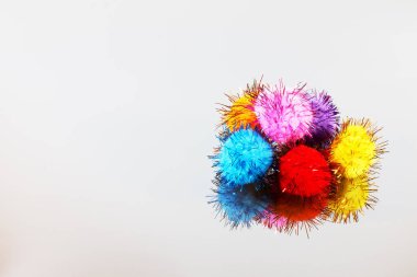 Gri bir arka plan üzerinde renkli güzel pompons