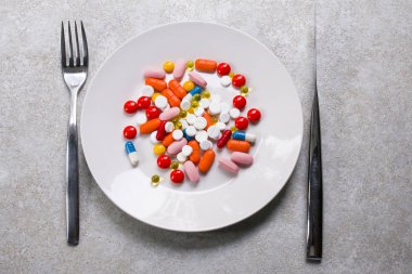 renkli tabletler ve vitaminler bir tabakta