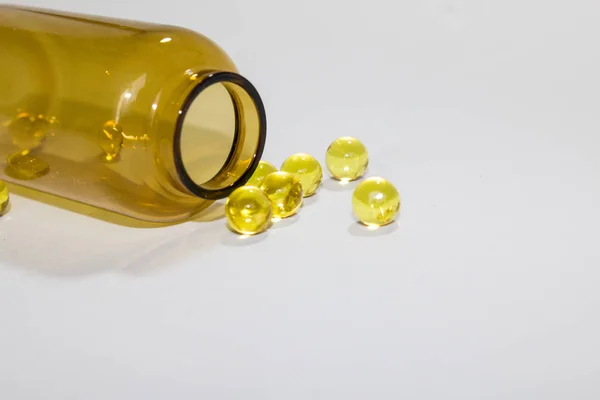 Żółte przezroczyste okrągłe tabletki w przezroczystej butelce — Zdjęcie stockowe