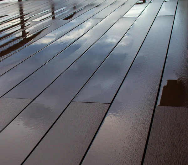 Wet floor. Board is wet after rain. sky reflected in a puddle on the floor. — Stock Photo, Image