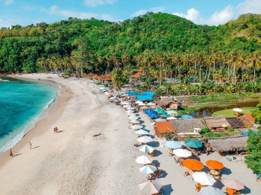 Tropik ada, Bali, Endonezya yazında şemsiye ile Güzel kristal berraklığında su ve beyaz plaj havadan görünümü