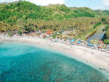 Tropik ada, Bali, Endonezya yazında şemsiye ile Güzel kristal berraklığında su ve beyaz plaj havadan görünümü