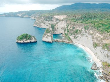 Nusa Penida, Bali, Endonezya inanılmaz mavi okyanus ile beyaz uçurum, okyanus, kaya, plaj, ağaç ve kıyı havadan drone görünümü