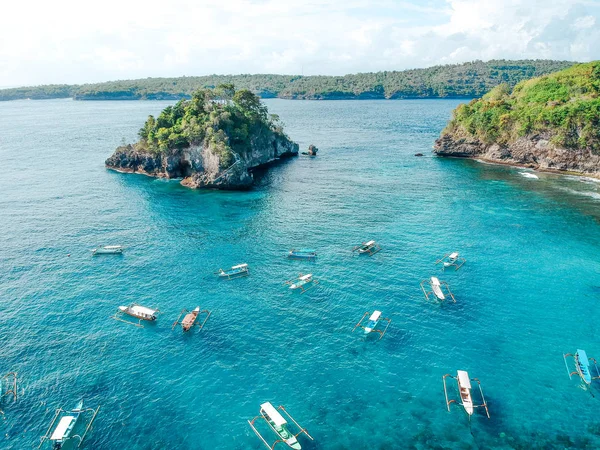 Nusa Penida Adası, Bali, Endonezya'da deniz kıyısının mavi okyanus görünümünde geleneksel balıkçı tekneleri ile plaj Güzel Hava görünümü