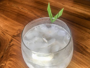 Taze hindistan cevizi suyu Bardak, doğal serin hindistan cevizi suyu içmek. Endonezya Buz hindistan cevizi içecek veya kelapa muda cam üzerinde yaprak ile izole ahşap arka plan