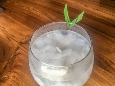 Taze hindistan cevizi suyu Bardak, doğal serin hindistan cevizi suyu içmek. Endonezya Buz hindistan cevizi içecek veya kelapa muda cam üzerinde yaprak ile izole ahşap arka plan