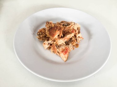 Beyaz arka planda izole edilmiş beyaz tabakta kırmızı biberli ve sarımsak aromalı Ayam geprek veya baharatlı tavuk ezmesi. Endonezya mutfağı baharatlı yemekleri