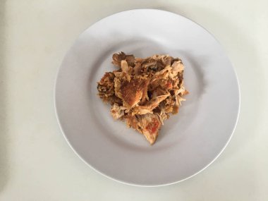 Beyaz arka planda izole edilmiş beyaz tabakta kırmızı biberli ve sarımsak aromalı Ayam geprek veya baharatlı tavuk ezmesi. Endonezya mutfağı baharatlı yemekleri