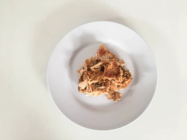 白い背景に隔離された白いプレート上に唐辛子とニンニクの風味とアイアム ゲプレックまたはスパイシーな鶏のクラッシュ インドネシア料理辛い食べ物 — ストック写真
