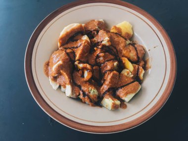 siomay Balık kek köfte patates, yumurta ve lahana rulo koyu arka plan üzerinde fıstık ve biber sosları ile servis