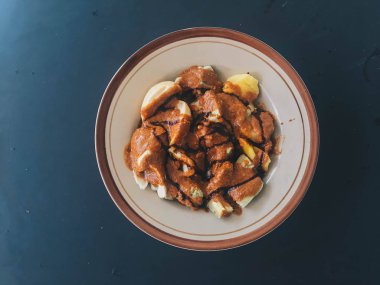 siomay Balık kek köfte patates, yumurta ve lahana rulo koyu arka plan üzerinde fıstık ve biber sosları ile servis