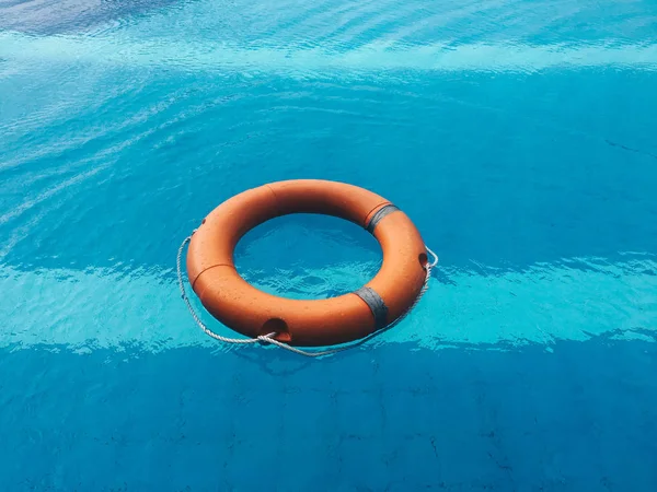 Life ring or Lifebuoy floating in a clear pool water