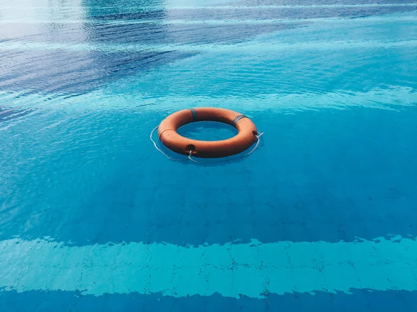 Life ring or Lifebuoy floating in a clear pool water