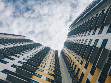 Bulutlu gökyüzü önünde yüksek katlı konut binası