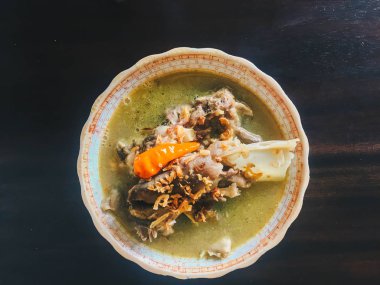 Tengkleng, ne kadar iyi. kaburga ve kemik çorba ile pişirilen keçi eti. Endonezya Geleneksel Gıda Barbekü Kuzu Kemiği siyah ahşap arka plan üzerinde izole yapılmış