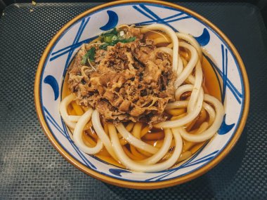 Biraz etli Japon yemeğinin Udon eriştesi. Siyah arka plan üzerinde izole masada bir kase yakın çekim. yukarıdan yatay üst görünüm 