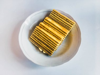 Lapis Kek veya Lapis Okunaklı. beyaz arka plan üzerinde izole beyaz plaka üzerinde geleneksel endonezya tatlı katmanlı kek. 